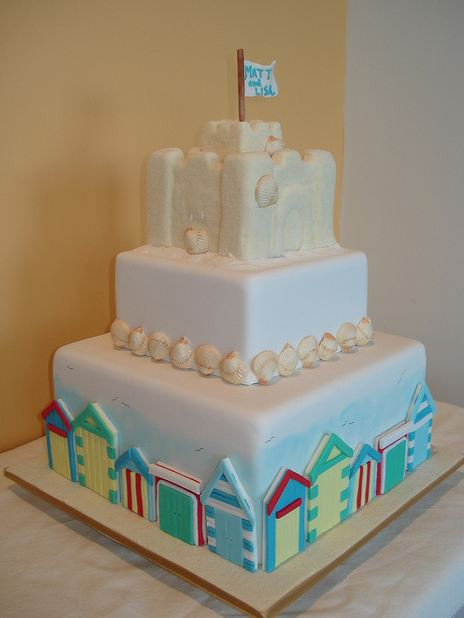 Sandcastle Wedding Cakes
 Three tier sand castle theme wedding cake with flag on top JPG