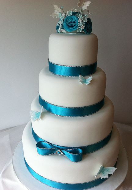 Wedding Cake Blue And White
 Four tier round white wedding cake with blue ribbons and